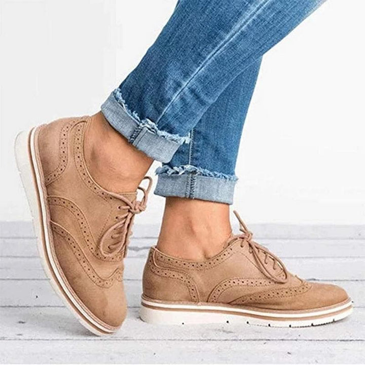 Derby femme en cuir velours, détails brogue, couleur élégante, lacets classiques, idéale pour un style raffiné.