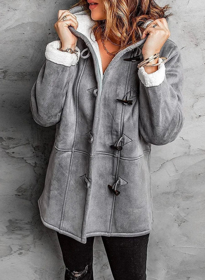 Manteau long en cachemire gris, coupe élégante avec capuche intégrée et boutons en corne, offrant chaleur et douceur.