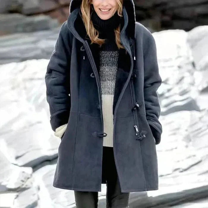 Manteau long en cachemire gris, coupe élégante avec capuche intégrée et boutons en corne, offrant chaleur et douceur.