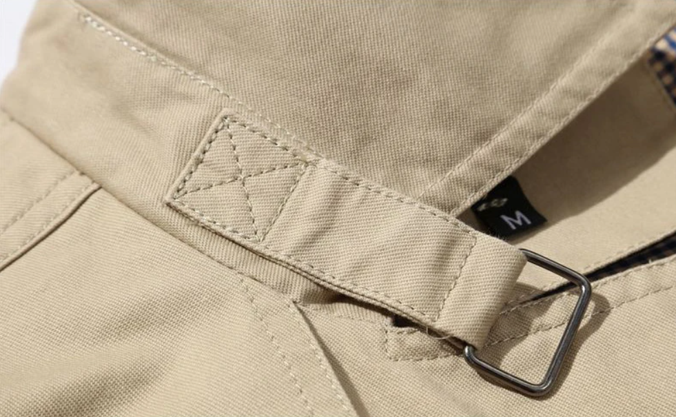 "Manteau trench homme élégant avec coupe structurée, doublure lisse, épaulettes marquées et style croisé sophistiqué."