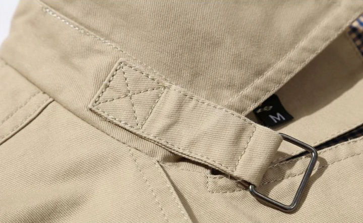 "Manteau trench homme élégant avec coupe structurée, doublure lisse, épaulettes marquées et style croisé sophistiqué."