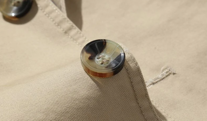 "Manteau trench homme élégant avec coupe structurée, doublure lisse, épaulettes marquées et style croisé sophistiqué."