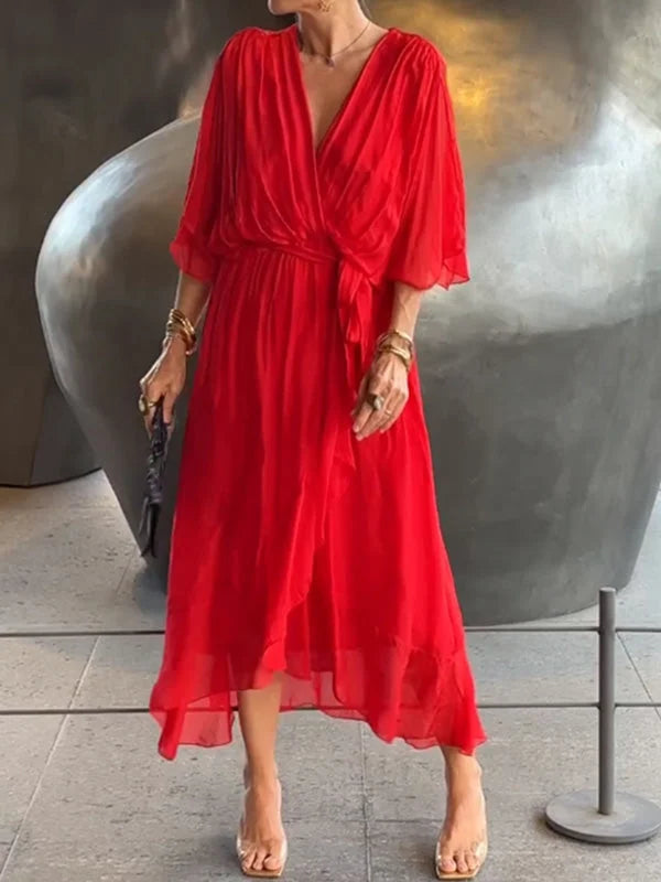 "Robe en mousseline de soie bleue avec col en V et manches 3/4, coupe fluide pour occasions élégantes."