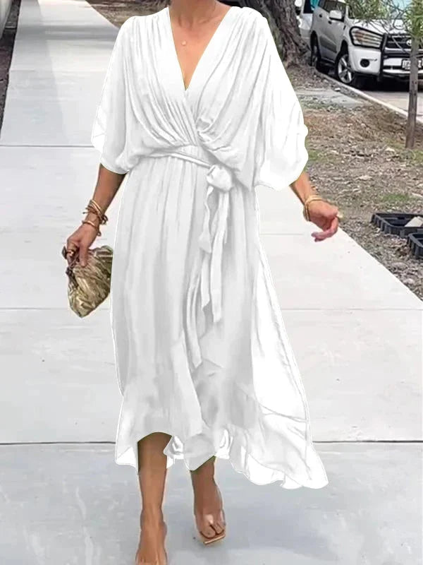 "Robe en mousseline de soie bleue avec col en V et manches 3/4, coupe fluide pour occasions élégantes."