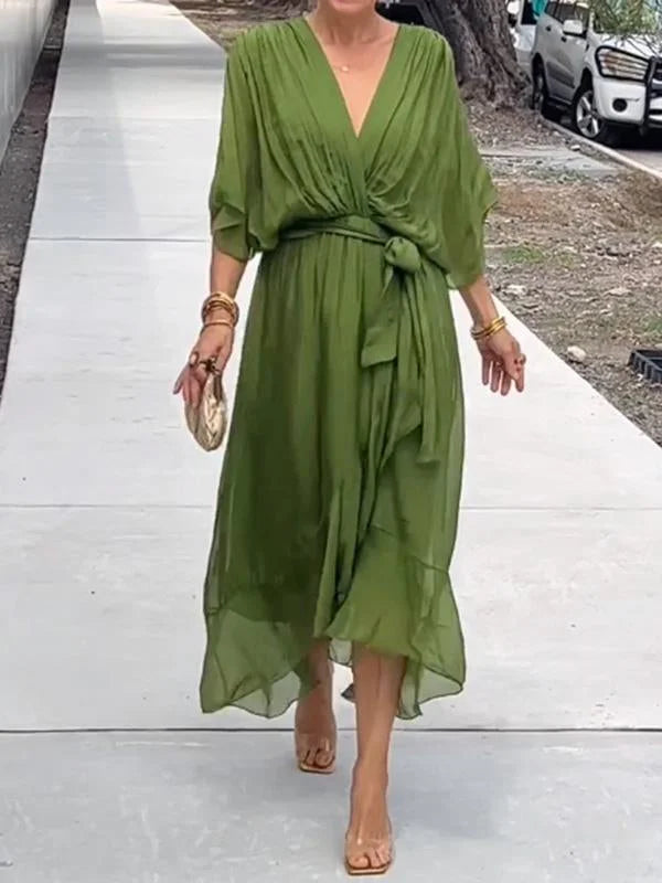 "Robe en mousseline de soie bleue avec col en V et manches 3/4, coupe fluide pour occasions élégantes."