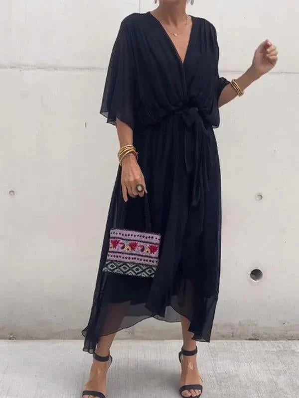 "Robe en mousseline de soie bleue avec col en V et manches 3/4, coupe fluide pour occasions élégantes."