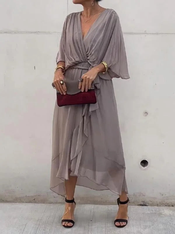 "Robe en mousseline de soie bleue avec col en V et manches 3/4, coupe fluide pour occasions élégantes."