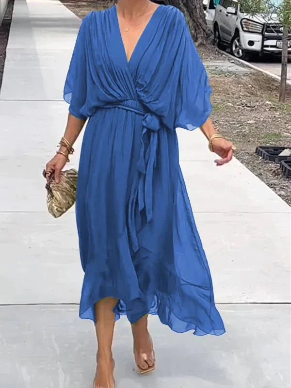 "Robe en mousseline de soie bleue avec col en V et manches 3/4, coupe fluide pour occasions élégantes."