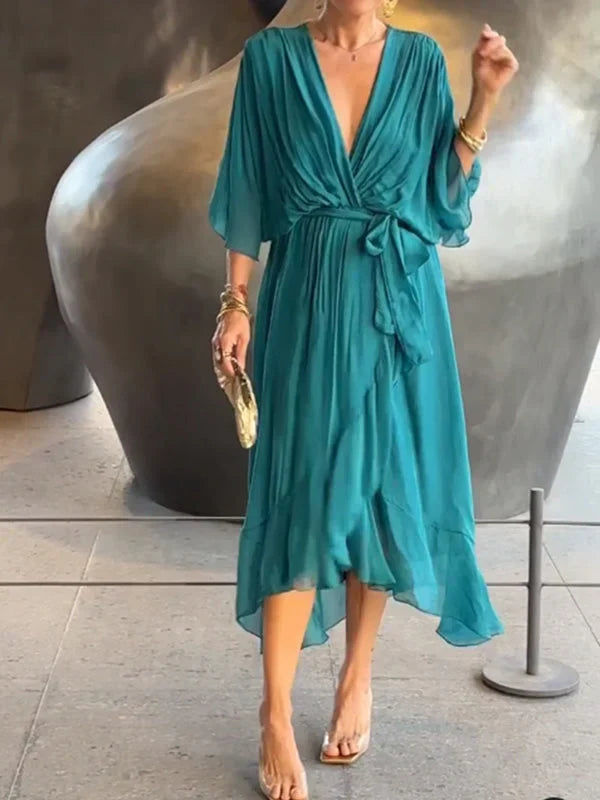 "Robe en mousseline de soie bleue avec col en V et manches 3/4, coupe fluide pour occasions élégantes."