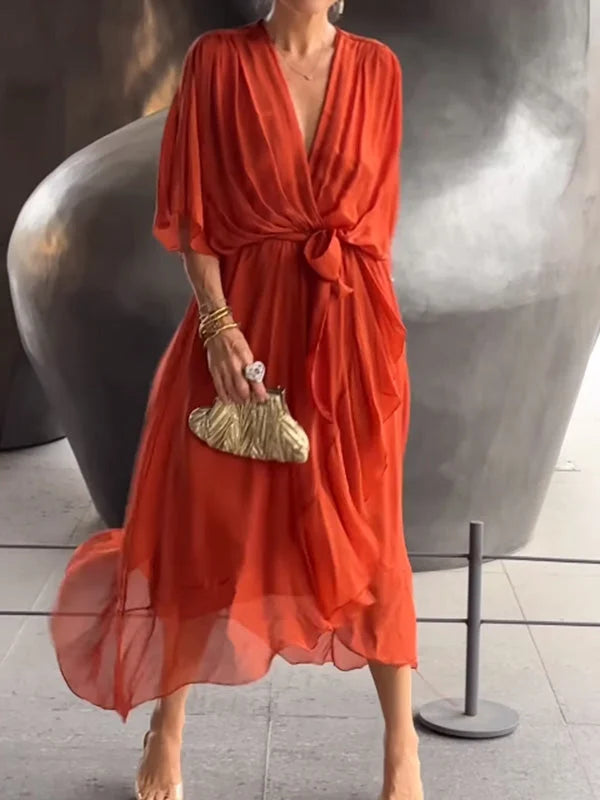 "Robe en mousseline de soie bleue avec col en V et manches 3/4, coupe fluide pour occasions élégantes."