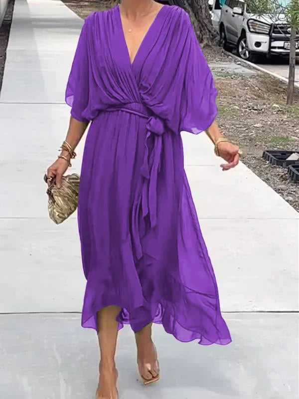 "Robe en mousseline de soie bleue avec col en V et manches 3/4, coupe fluide pour occasions élégantes."