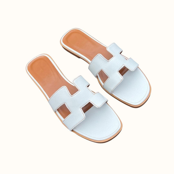 Sandales H-Stylé pour femmes en cuir, design moderne en H, talon plat, couleur beige, élégance et confort pour l'été.