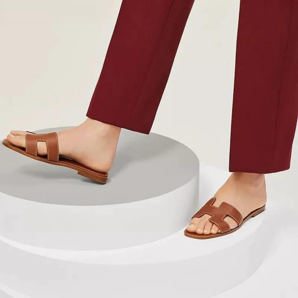Sandales H-Stylé pour femmes en cuir, design moderne en H, talon plat, couleur beige, élégance et confort pour l'été.