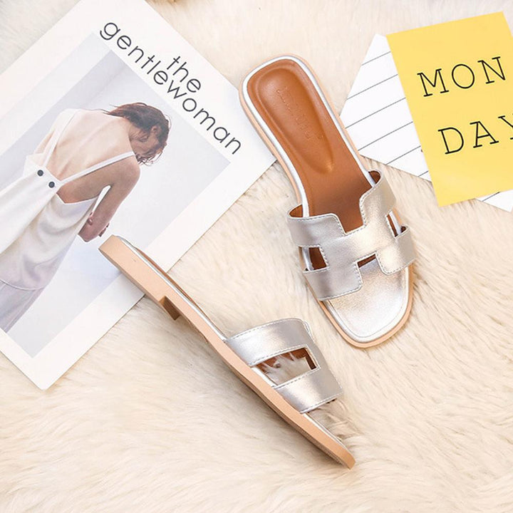 Sandales H-Stylé pour femmes en cuir, design moderne en H, talon plat, couleur beige, élégance et confort pour l'été.