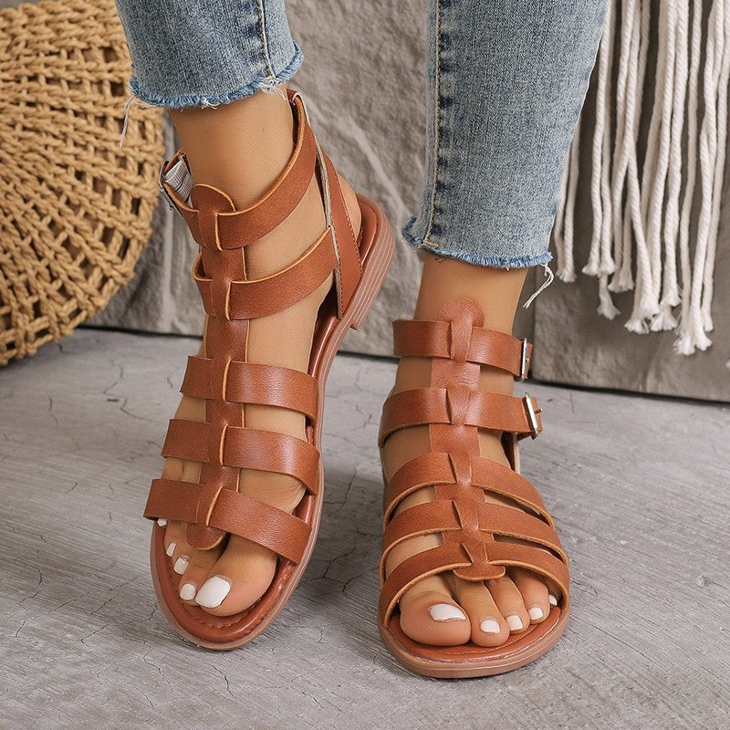Sandales plates femme en similicuir beige style romain avec boucles réglables et bout ouvert, vue de face.
