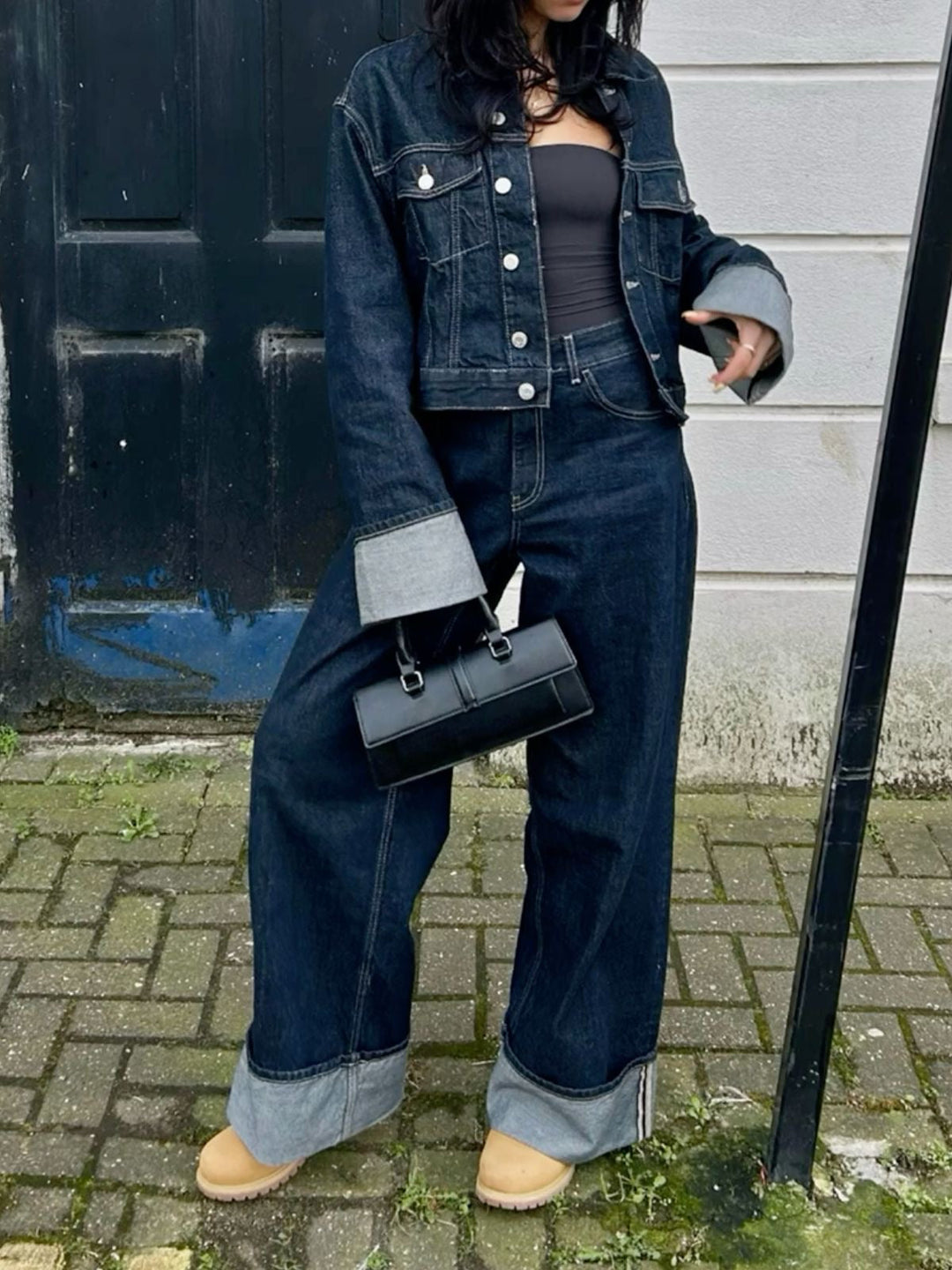 Veste courte en denim ajustée avec boutons métalliques et jean large taille haute à revers contrastés pour look urbain.