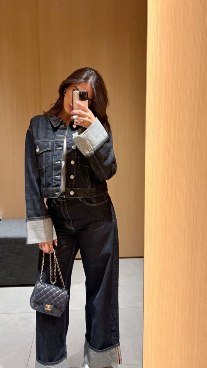 Veste courte en denim ajustée avec boutons métalliques et jean large taille haute à revers contrastés pour look urbain.