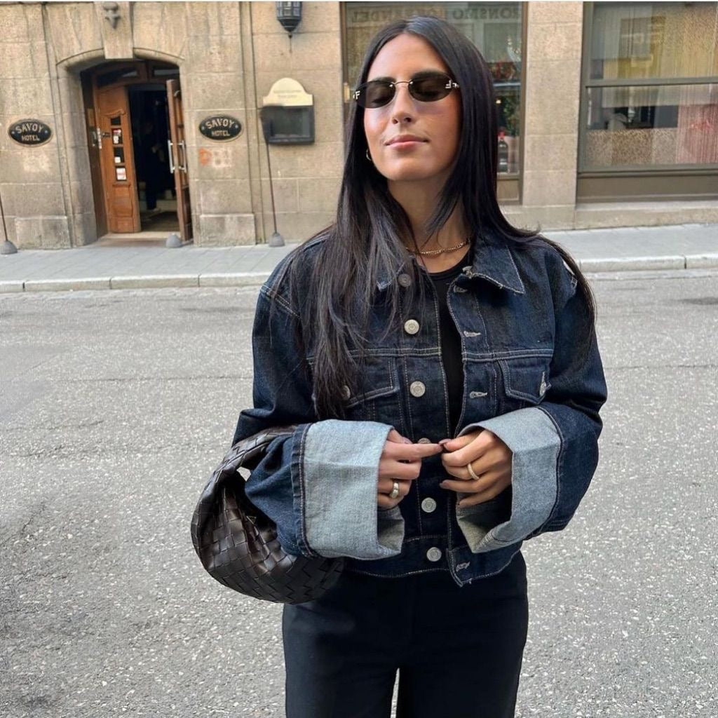 Veste courte en denim ajustée avec boutons métalliques et jean large taille haute à revers contrastés pour look urbain.