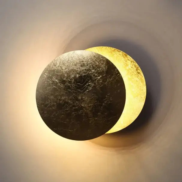 "Applique murale LED moderne, design éclipse scandinave, structure cuivre, finition laiton doré, lumière douce."
