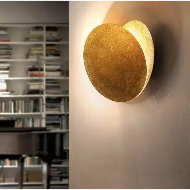 "Applique murale LED moderne, design éclipse scandinave, structure cuivre, finition laiton doré, lumière douce."