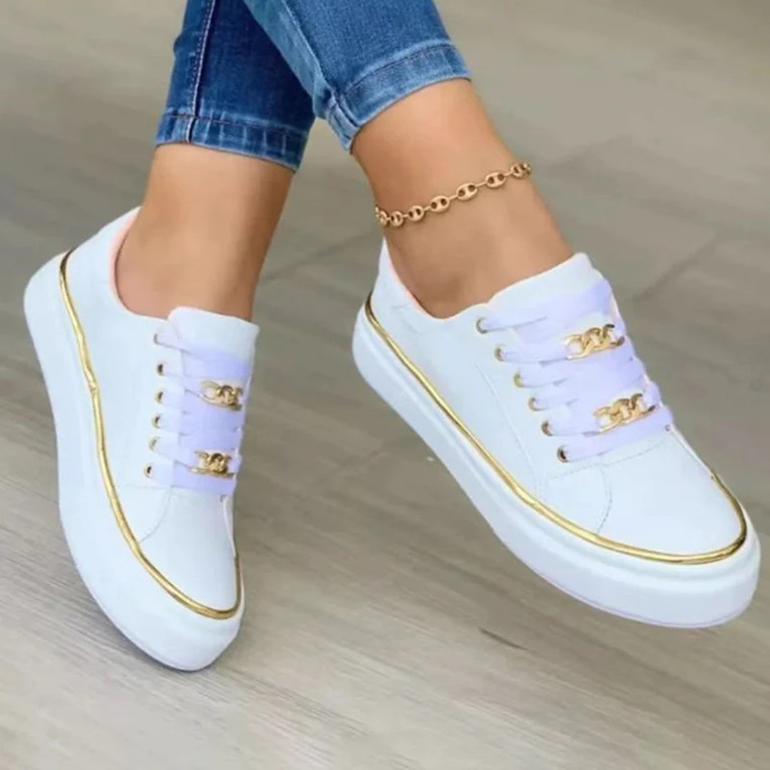 "Baskets femme blanches élégantes avec détail doré, coupe basse, style chic, design moderne et féminin."