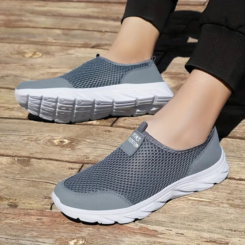 "Baskets respirantes homme sans lacets, maille grise, semelle flexible, style moderne et confort optimal au quotidien."