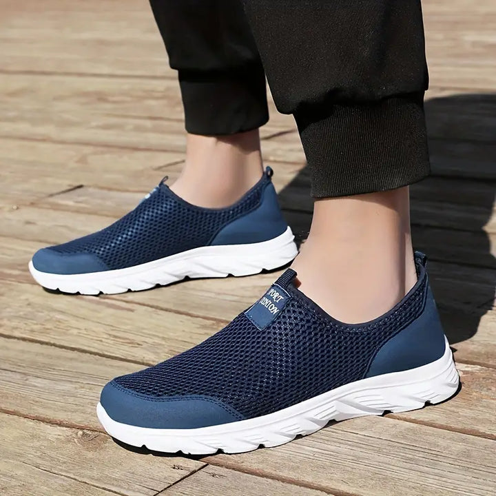 "Baskets respirantes homme sans lacets, maille grise, semelle flexible, style moderne et confort optimal au quotidien."
