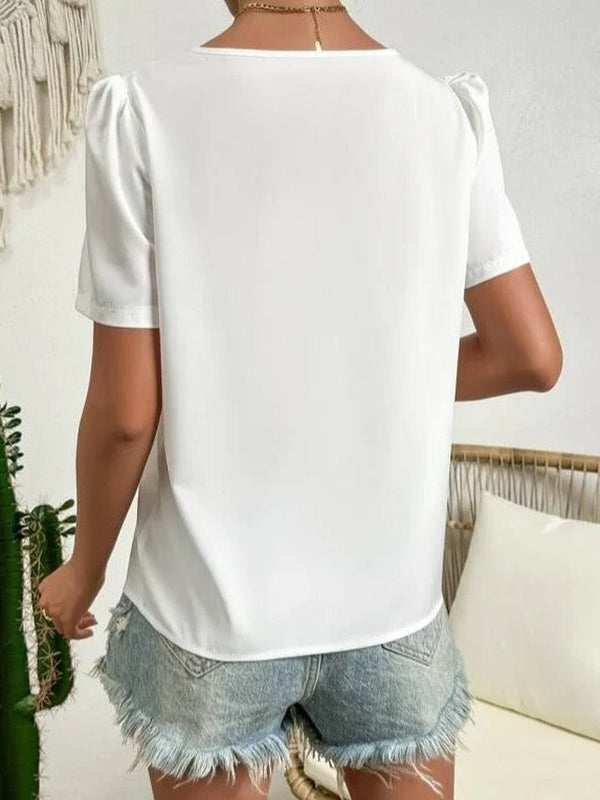 Blouse d'été blanche femme, col asymétrique, manches bouffantes, élégante, tissu léger, idéale pour les sorties estivales.