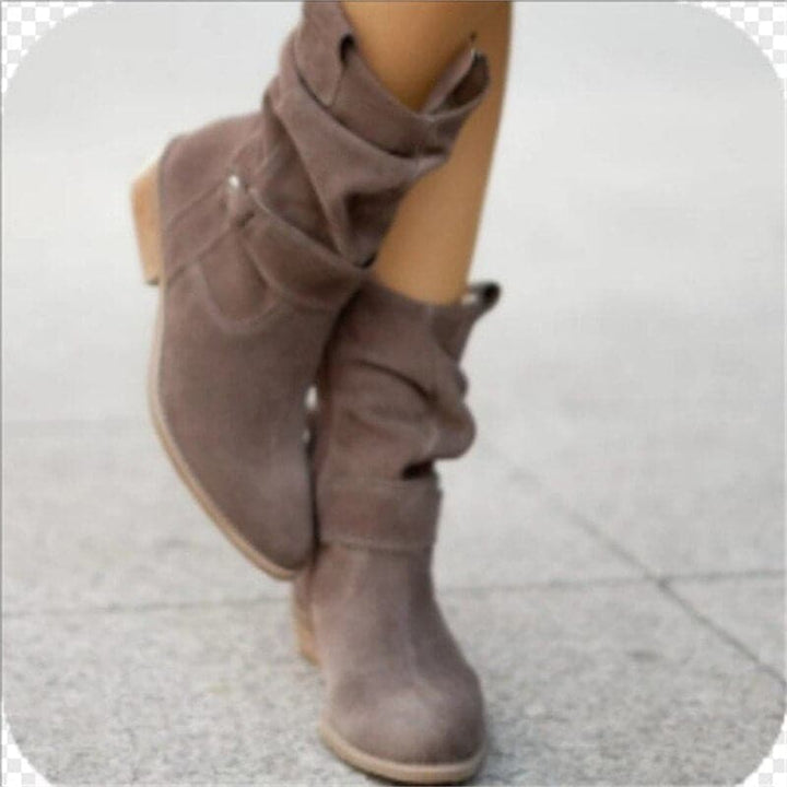 "Bottes femme en daim élégant, coupe ample, lanières et boucles décoratives, style automne-hiver."