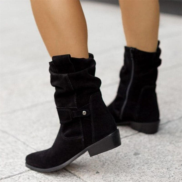 "Bottes femme en daim élégant, coupe ample, lanières et boucles décoratives, style automne-hiver."