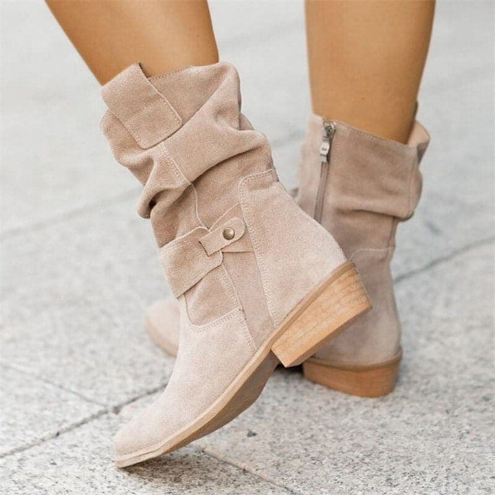 "Bottes femme en daim élégant, coupe ample, lanières et boucles décoratives, style automne-hiver."