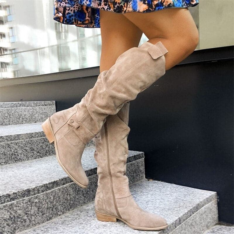 "Bottes femme en daim élégant, coupe ample, lanières et boucles décoratives, style automne-hiver."
