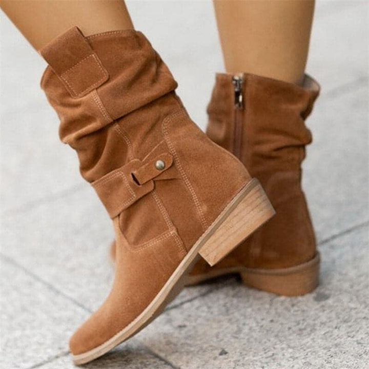 "Bottes femme en daim élégant, coupe ample, lanières et boucles décoratives, style automne-hiver."