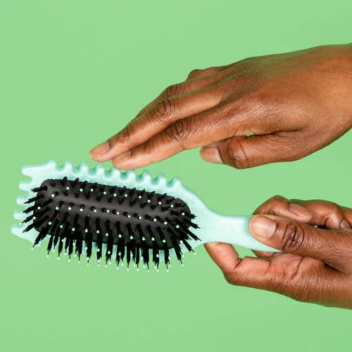 "Brosse coiffante 3-en-1 pour boucles, manche ergonomique, idéale pour dompter frisottis, en blanc laiteux ou vert clair."
