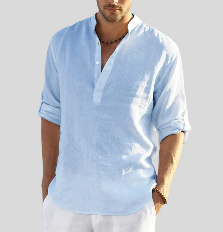 Chemise en lin homme élégante, manches repliées, col boutonné partiel, tissu léger blanc, style décontracté et estival.