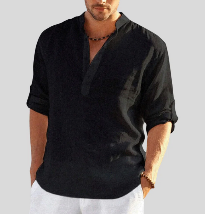 Chemise en lin homme élégante, manches repliées, col boutonné partiel, tissu léger blanc, style décontracté et estival.