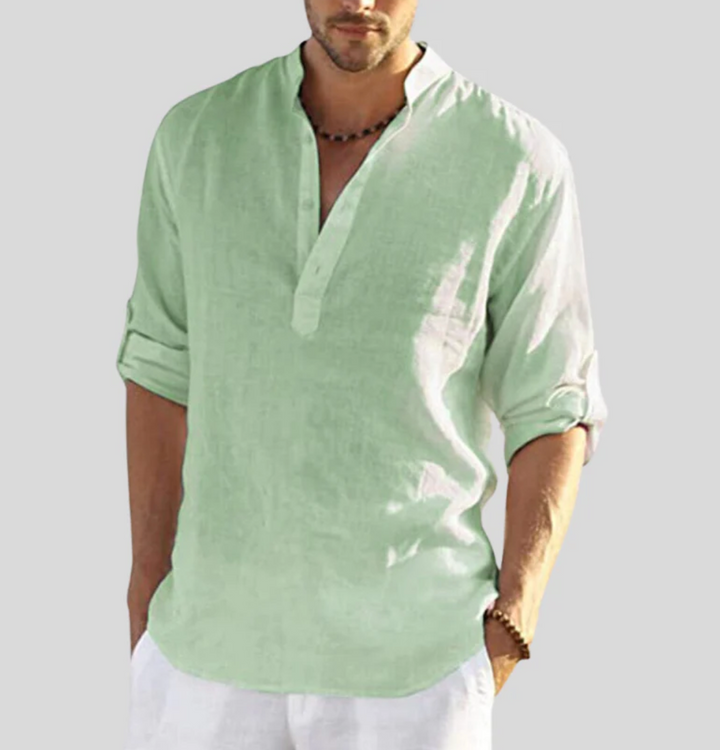 Chemise en lin homme élégante, manches repliées, col boutonné partiel, tissu léger blanc, style décontracté et estival.