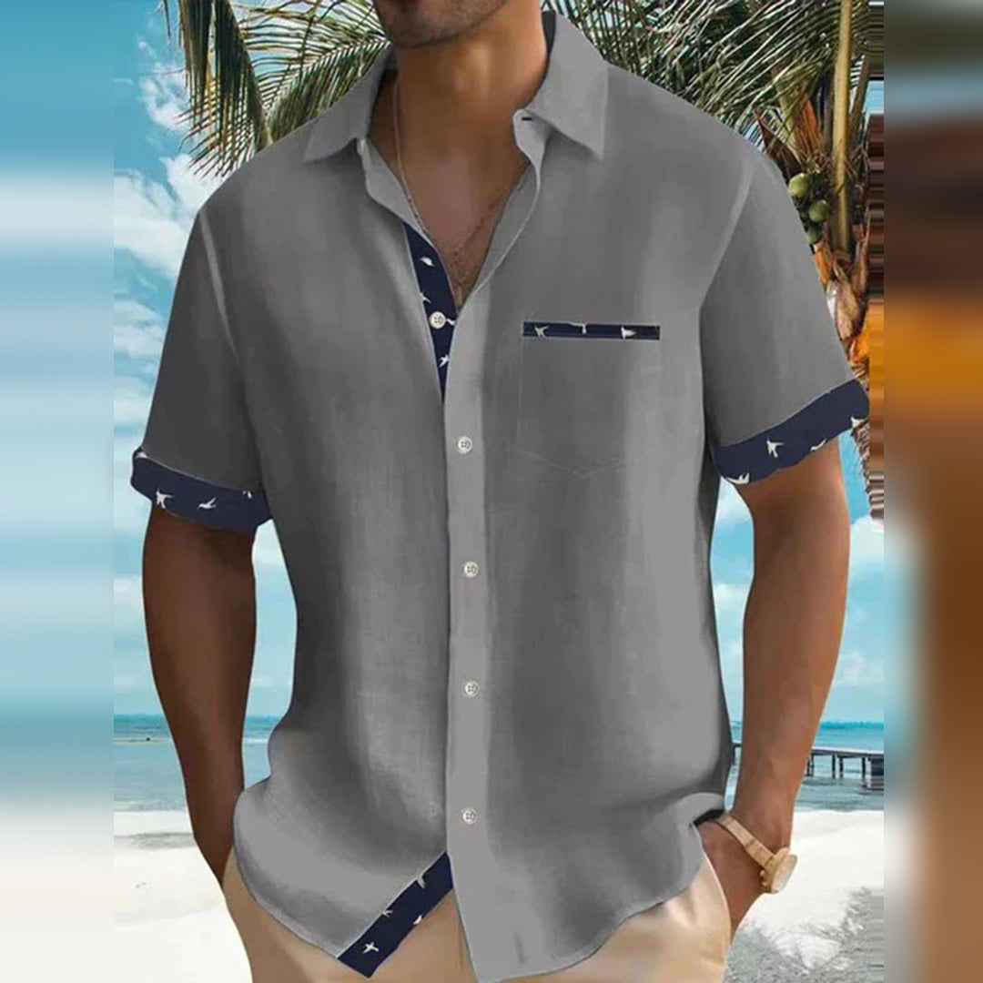 Chemise homme élégante grise à manches courtes avec détails contrastés, parfaite pour un style raffiné et estival.