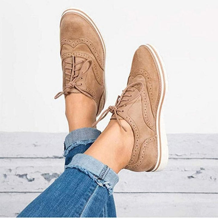 Derby femme en cuir velours, détails brogue, couleur élégante, lacets classiques, idéale pour un style raffiné.