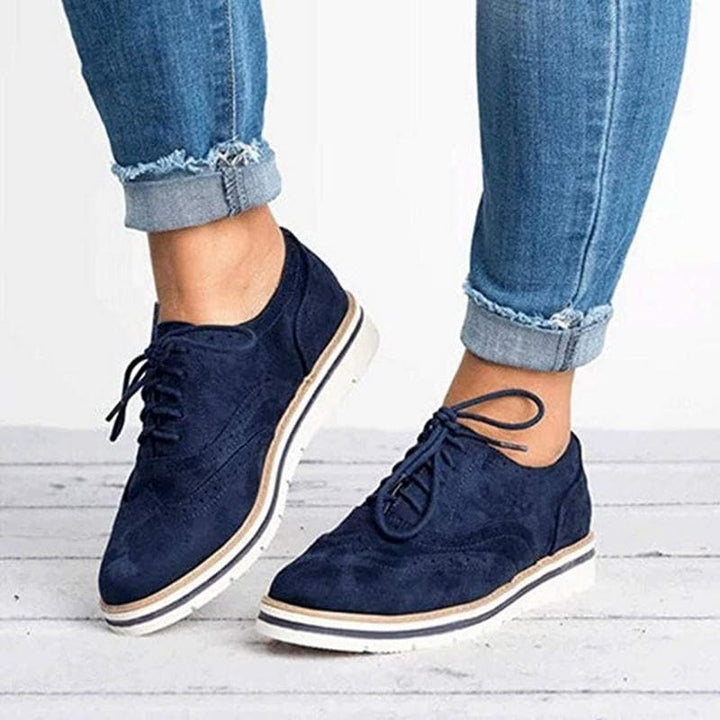 Derby femme en cuir velours, détails brogue, couleur élégante, lacets classiques, idéale pour un style raffiné.