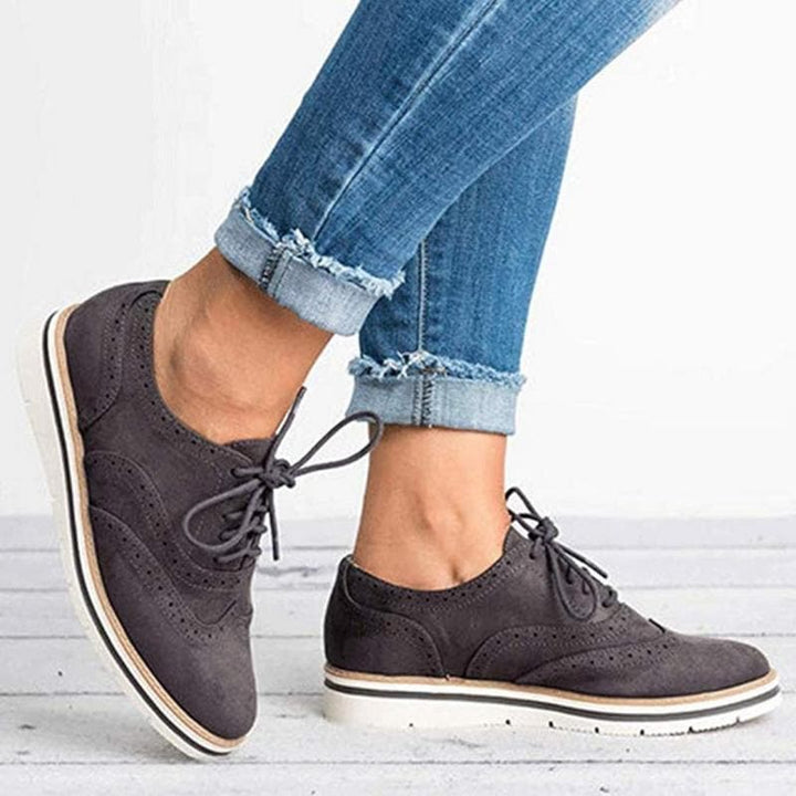 Derby femme en cuir velours, détails brogue, couleur élégante, lacets classiques, idéale pour un style raffiné.