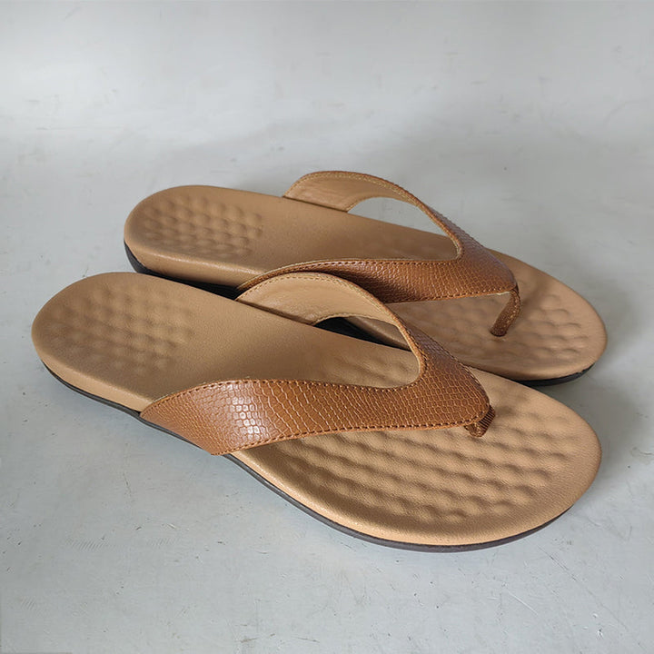 "Des tongs blanches élégantes et légères pour femmes sur fond beige, idéales pour l'été avec une semelle ergonomique."