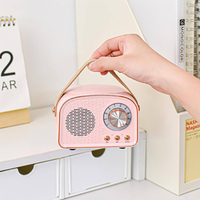 "Enceinte Bluetooth vintage au design rétro, radio FM intégrée, compacte, élégante, son clair, options de couleurs variées."