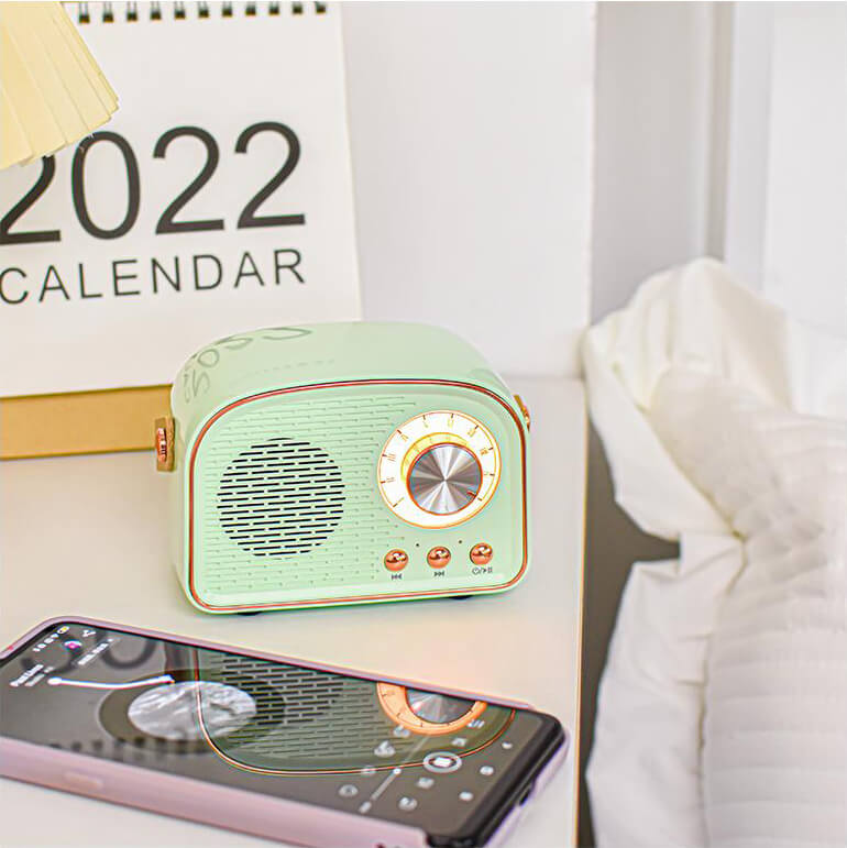 "Enceinte Bluetooth vintage au design rétro, radio FM intégrée, compacte, élégante, son clair, options de couleurs variées."