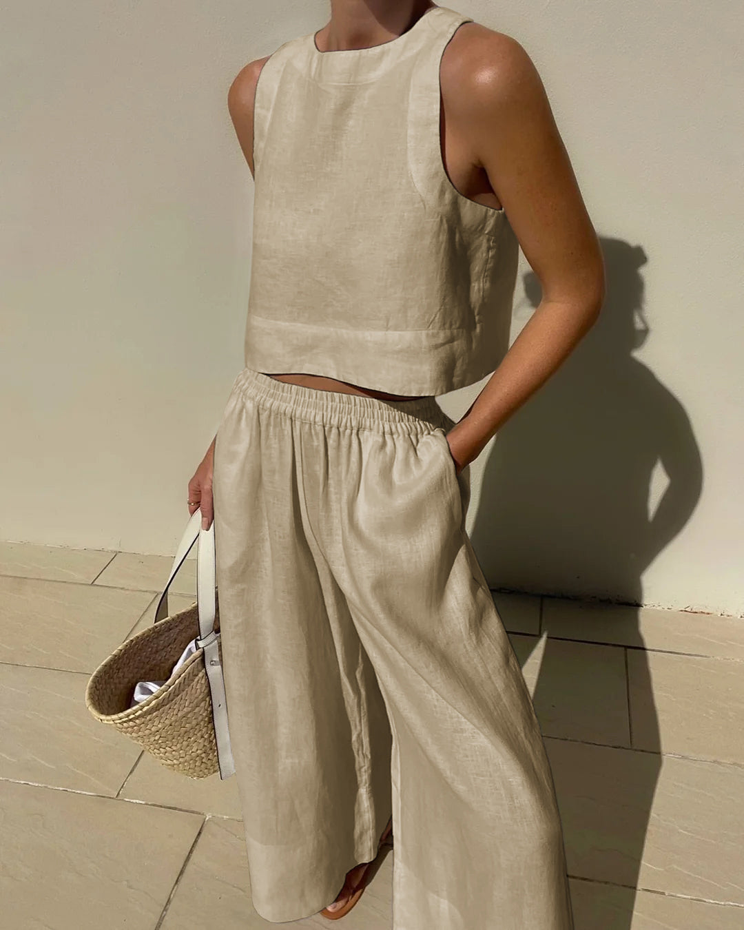 Ensemble femme en lin léger, haut sans manches minimaliste, pantalon large fluide, idéal pour style estival élégant.