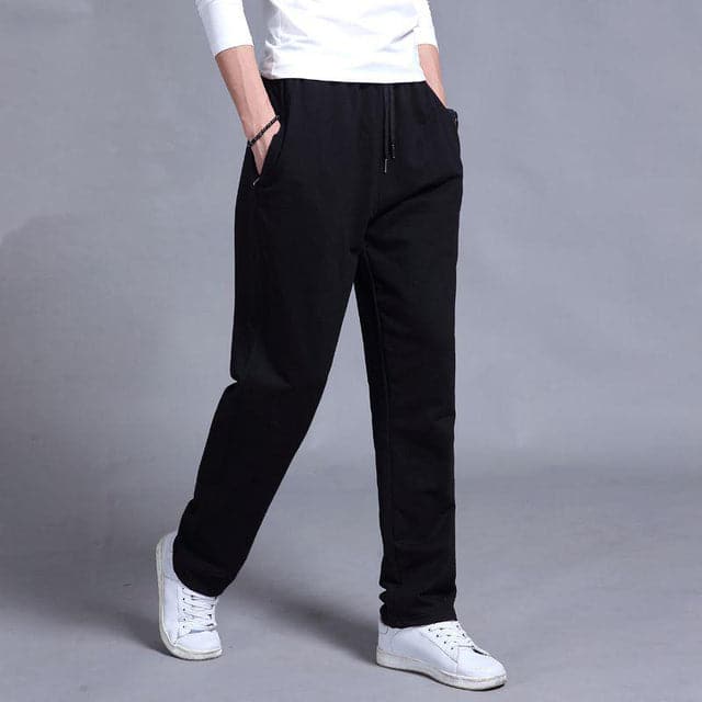 "Joggers noirs pour homme, style urbain et décontracté, avec coupe fuselée et poches zippées pratiques."