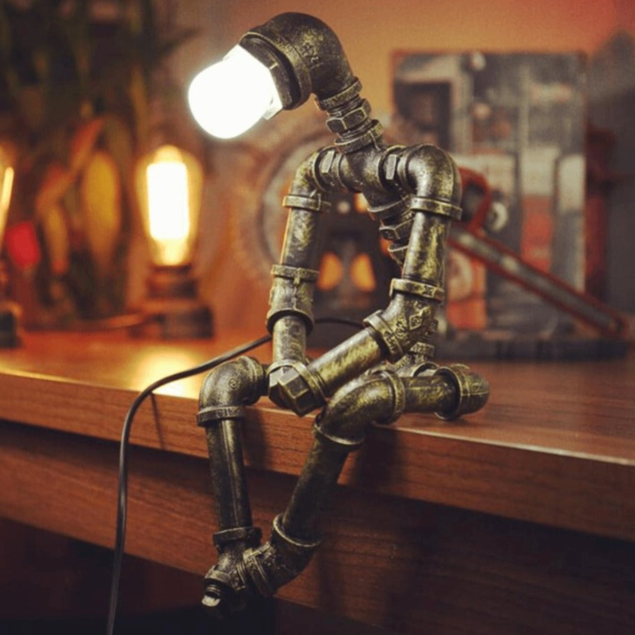 Lampe design robot en fer à éclairage ajustable rétro, bras et tête mobiles, finition couleur laiton, style industriel.