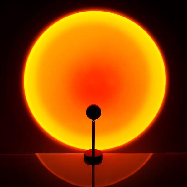 "Lampe LED ambiance soleil, multicolore, projette teintes chaudes; tête réglable 180°, diverses lentilles interchangeables."