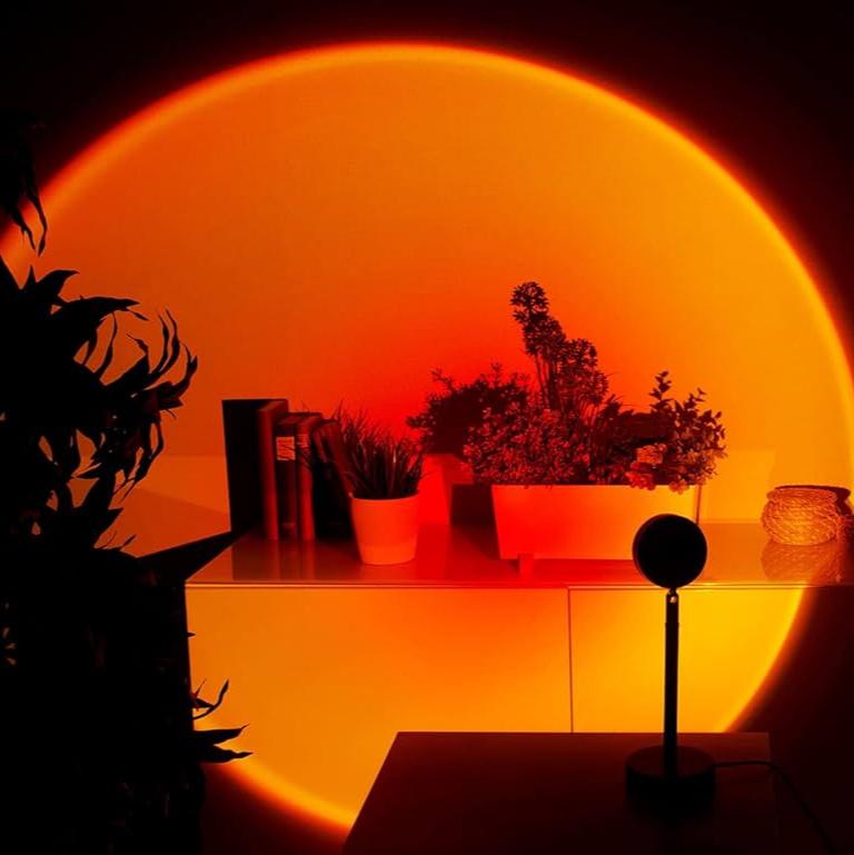 "Lampe LED ambiance soleil, multicolore, projette teintes chaudes; tête réglable 180°, diverses lentilles interchangeables."