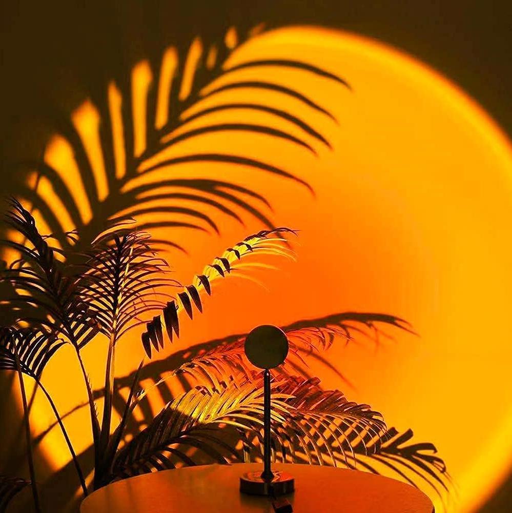 "Lampe LED ambiance soleil, multicolore, projette teintes chaudes; tête réglable 180°, diverses lentilles interchangeables."
